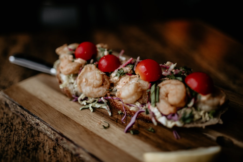 a wooden cutting board topped with food on top of a table