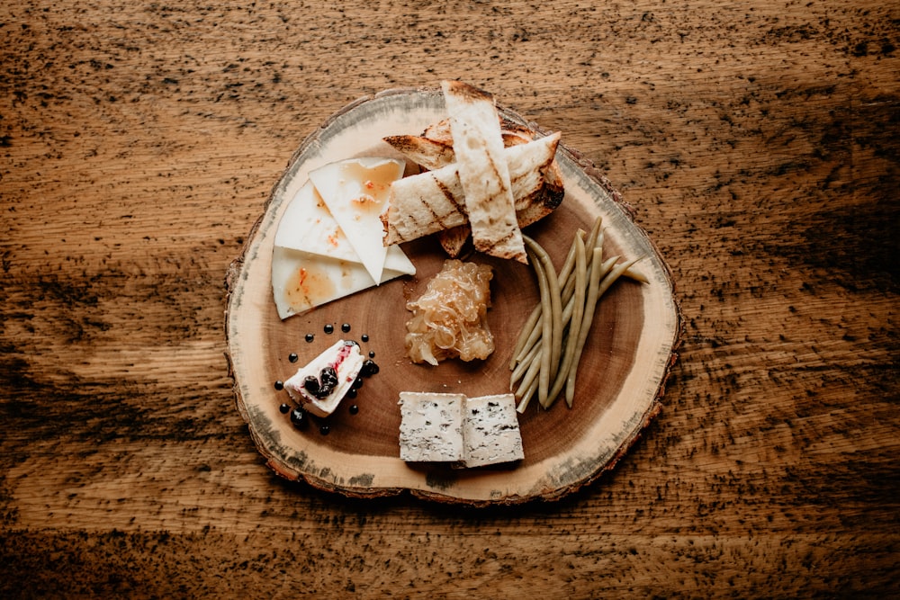 a wooden plate topped with cheese and crackers