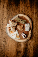 A spread of homemade jams and honey jars with rustic bread slices on a wooden board.