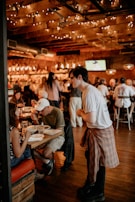 Cheerful diners enjoying meals inside a cozy, warmly-lit restaurant space
