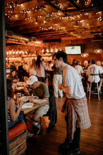 Guests enjoying a lively and cozy atmosphere with warm lighting and friendly service.