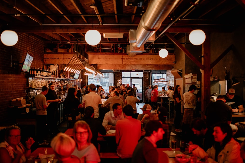 a group of people sitting at tables in a restaurant