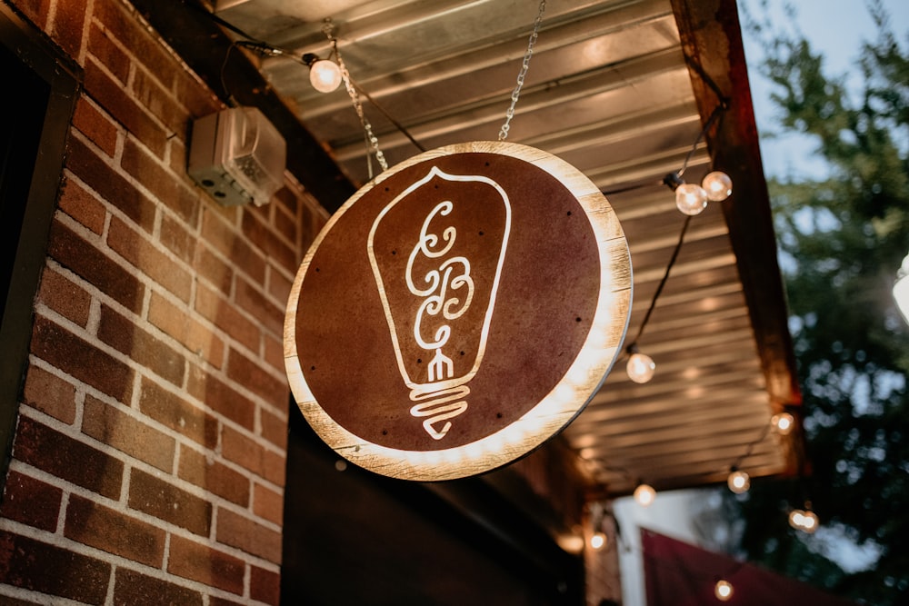 a light bulb sign hanging from the side of a building