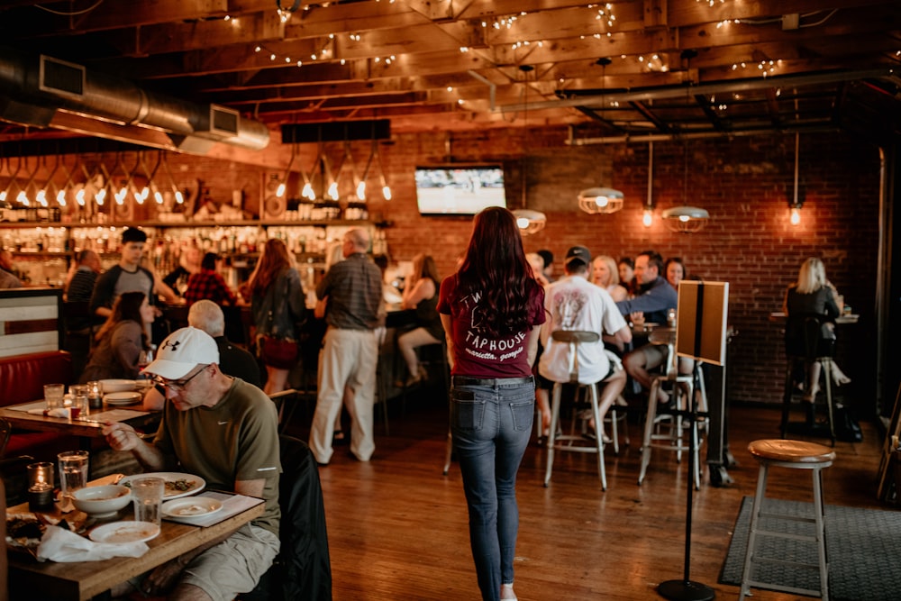 a group of people sitting at tables in a restaurant