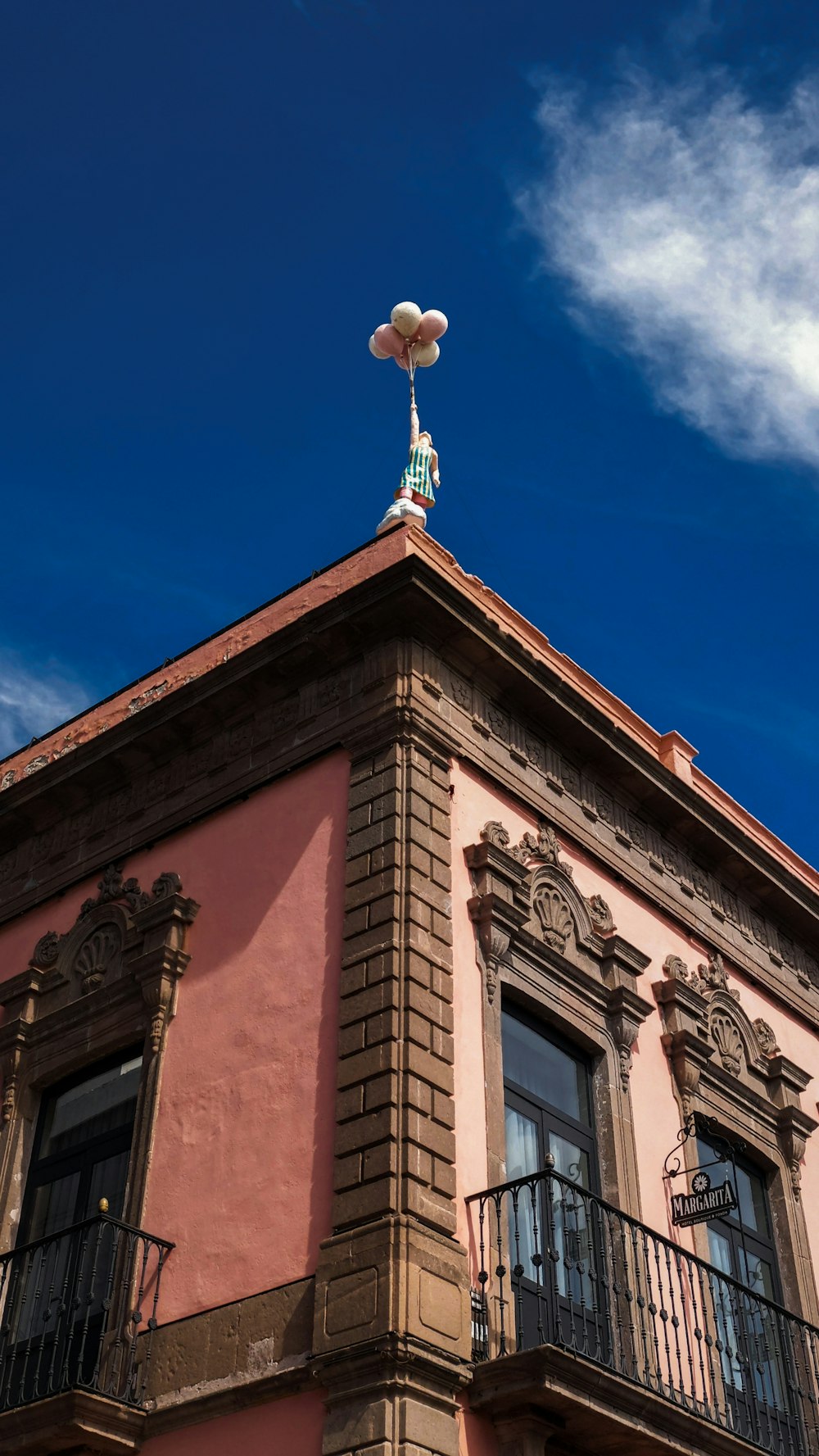 a building with a balcony and a weather vane on top