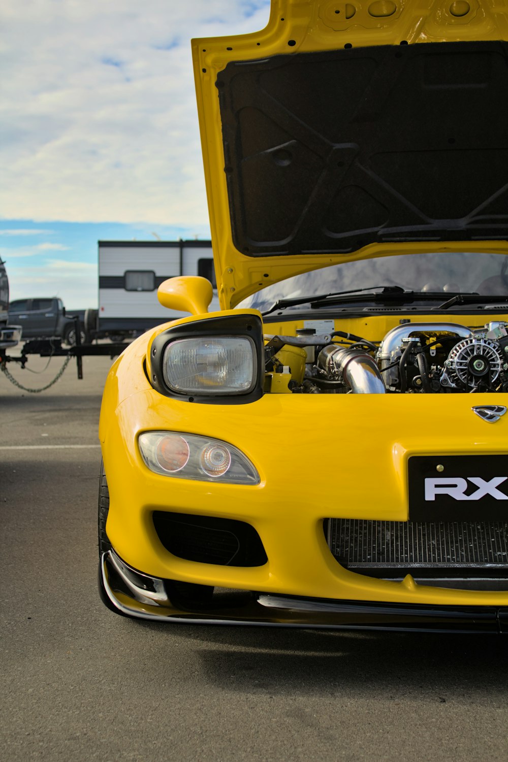 a yellow sports car with its hood open