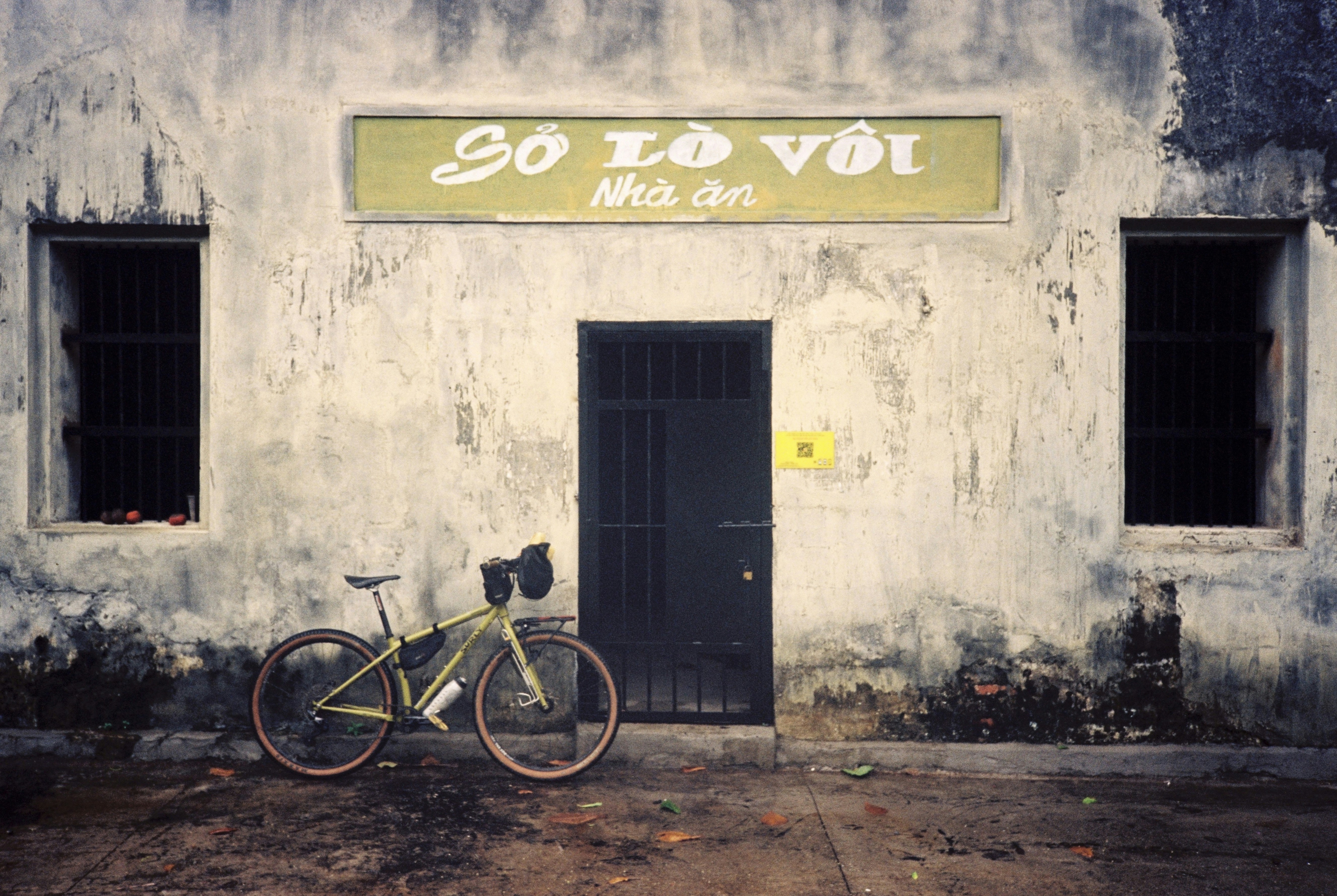 a bike parked in front of a building, Ride on Con Dao