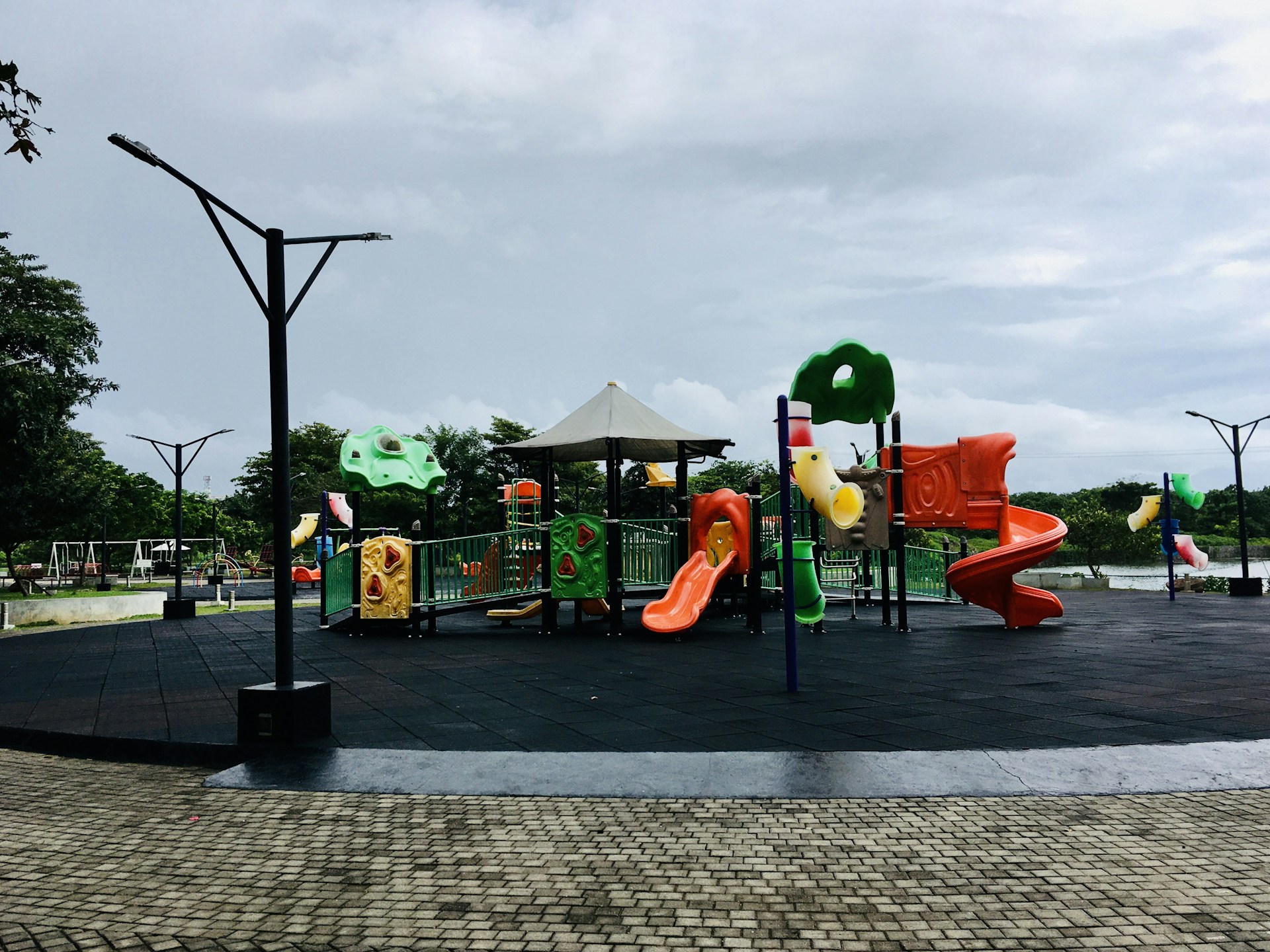 An outdoor play area where children are playing safely under the watchful eye of a caring staff member.