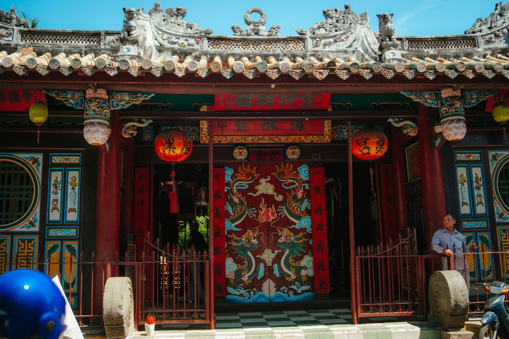 a man standing in front of a red building