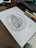 A laptop screen displaying elegant Arabic calligraphy templates surrounded by design sketches and coffee.