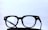 Black-framed eyeglasses placed on a dark surface with a light, minimalistic background. The glasses have a classic design with clear lenses.