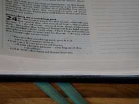 A close-up of an open book displaying text, with a section titled 'Jerusalem as a cooking pot.' The text includes numerical and paragraphed verses along with indented instructions.