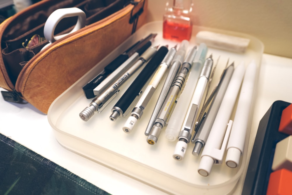 a bunch of pens are sitting on a tray