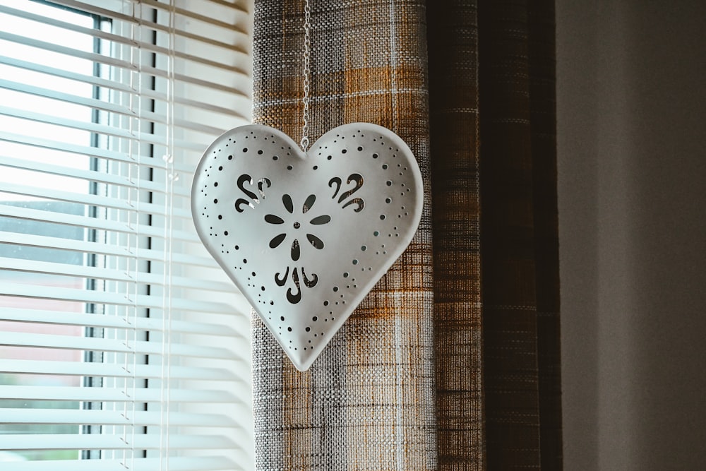 a decorative heart hanging on a window sill