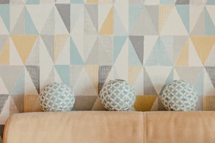 three vases sitting on a couch in front of a wall