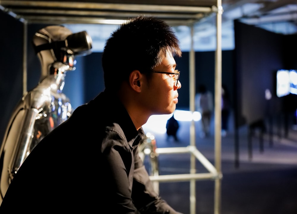 a man sitting in front of a bike in a room