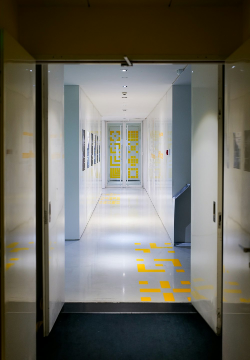 a long hallway with yellow squares on the floor