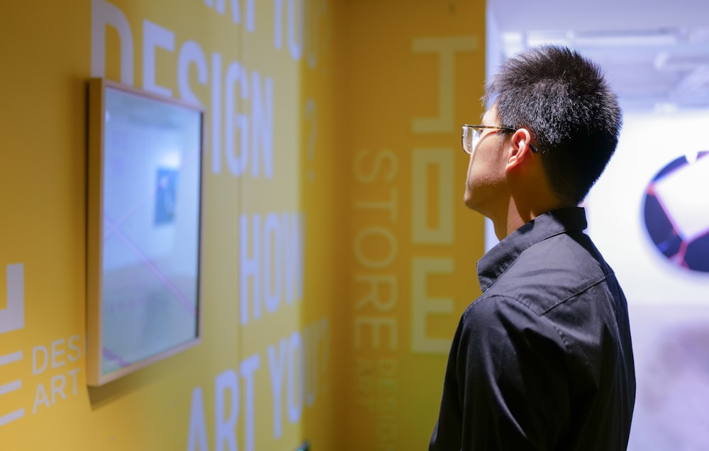 a man standing in front of a yellow wall