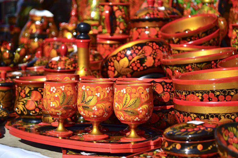 A collection of colorful, hand-painted religious cups arranged on a wooden table.