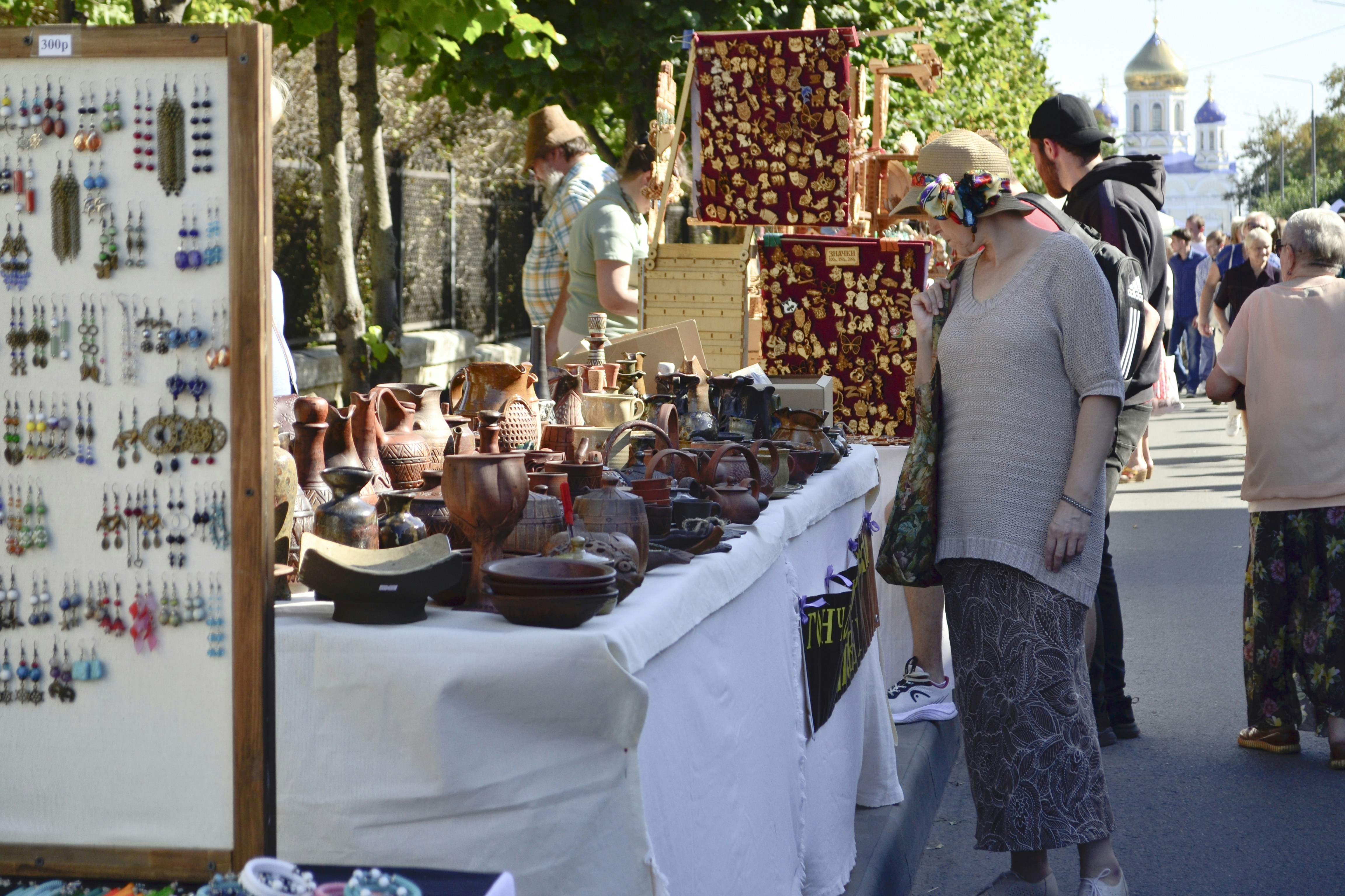 a couple of people standing next to a table with a lot of items on it