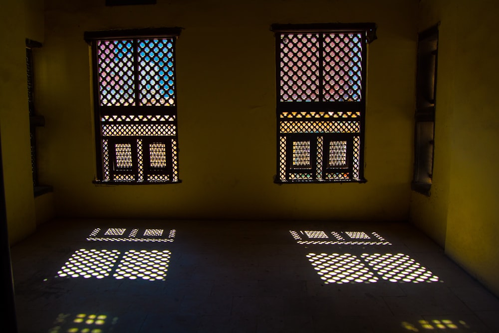 a room with three windows and three windows with lattices on them