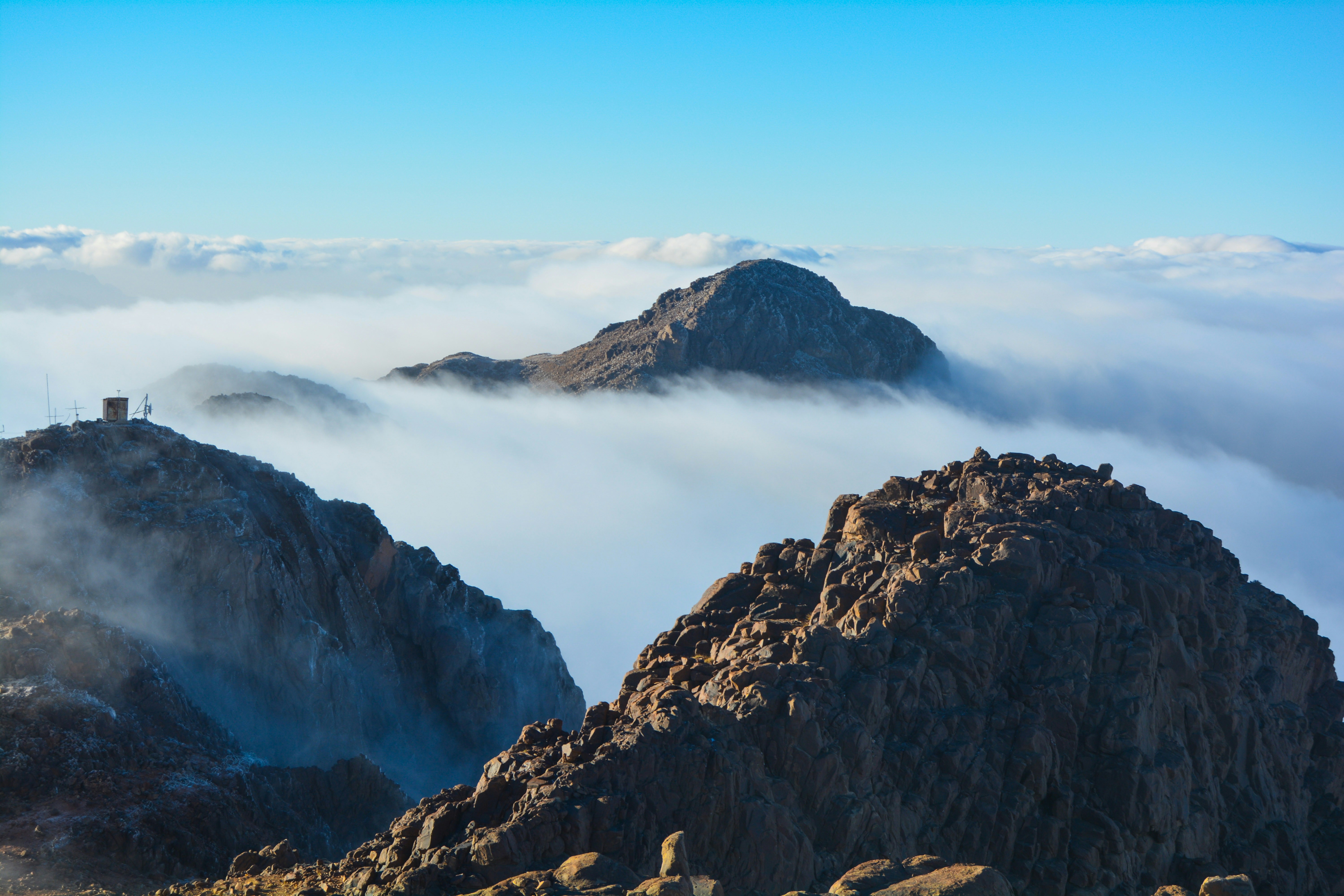 a mountain with a tower in the middle surrounded by clouds, From the highest point in Egypt.
