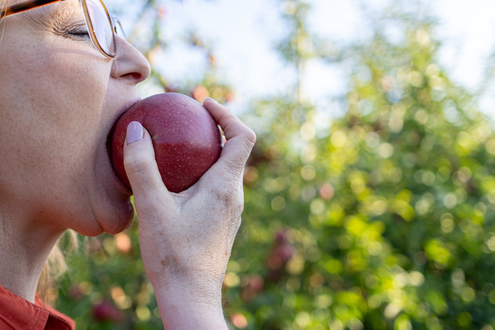 Une femme mangeant une pomme les yeux fermés