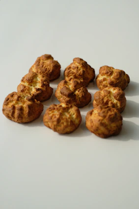 Array of gluten-free pastries arranged on a beige linen cloth with soft natural light.