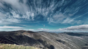 Rolling green fields and distant hills under a soft pastel sky near Biecz