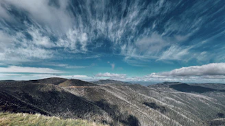 Rolling green fields and distant hills under a soft pastel sky near Biecz