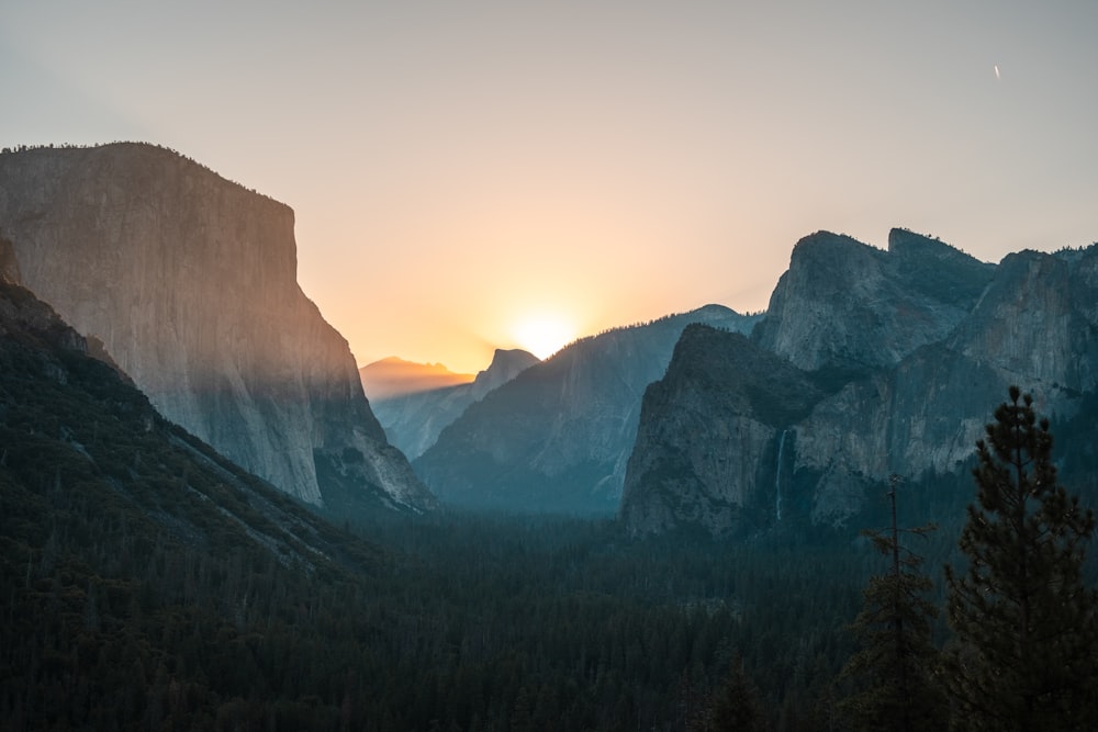 the sun is setting over a mountain range