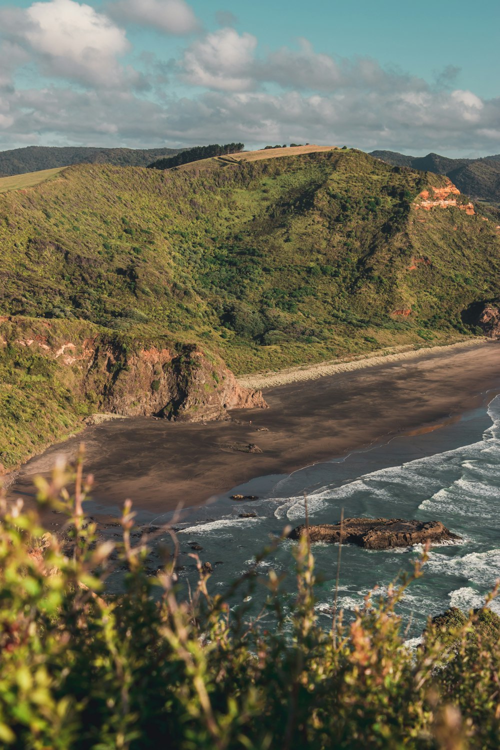 a view of a beach with a hill in the background