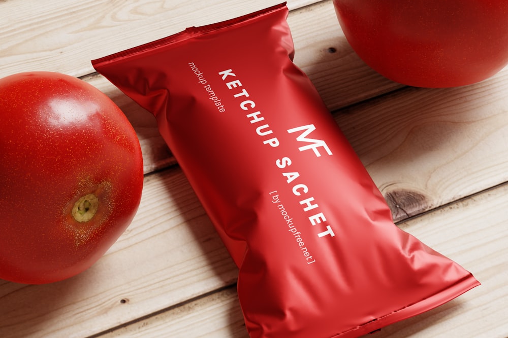 a bag of ketchup and a tomato on a wooden table