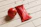 Close-up of a hand holding a sachet of tomato paste over a rustic wooden table