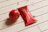 Close-up of a hand holding a sachet of tomato paste over a rustic wooden table