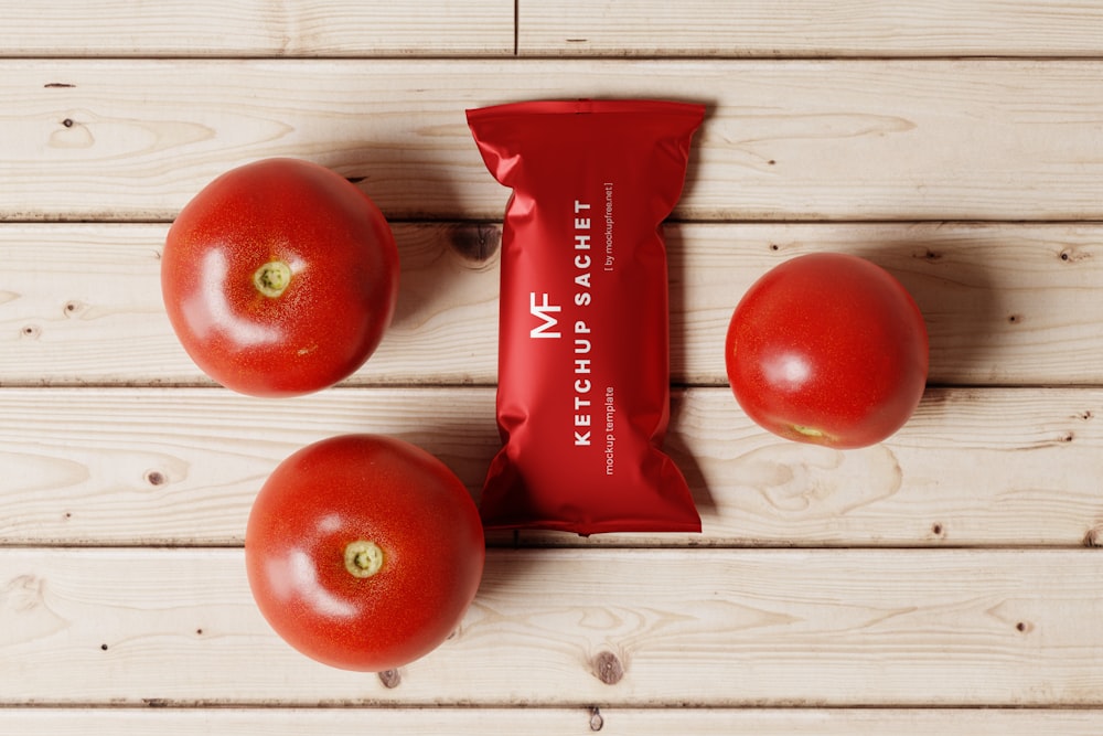 a bag of ketchup next to three tomatoes