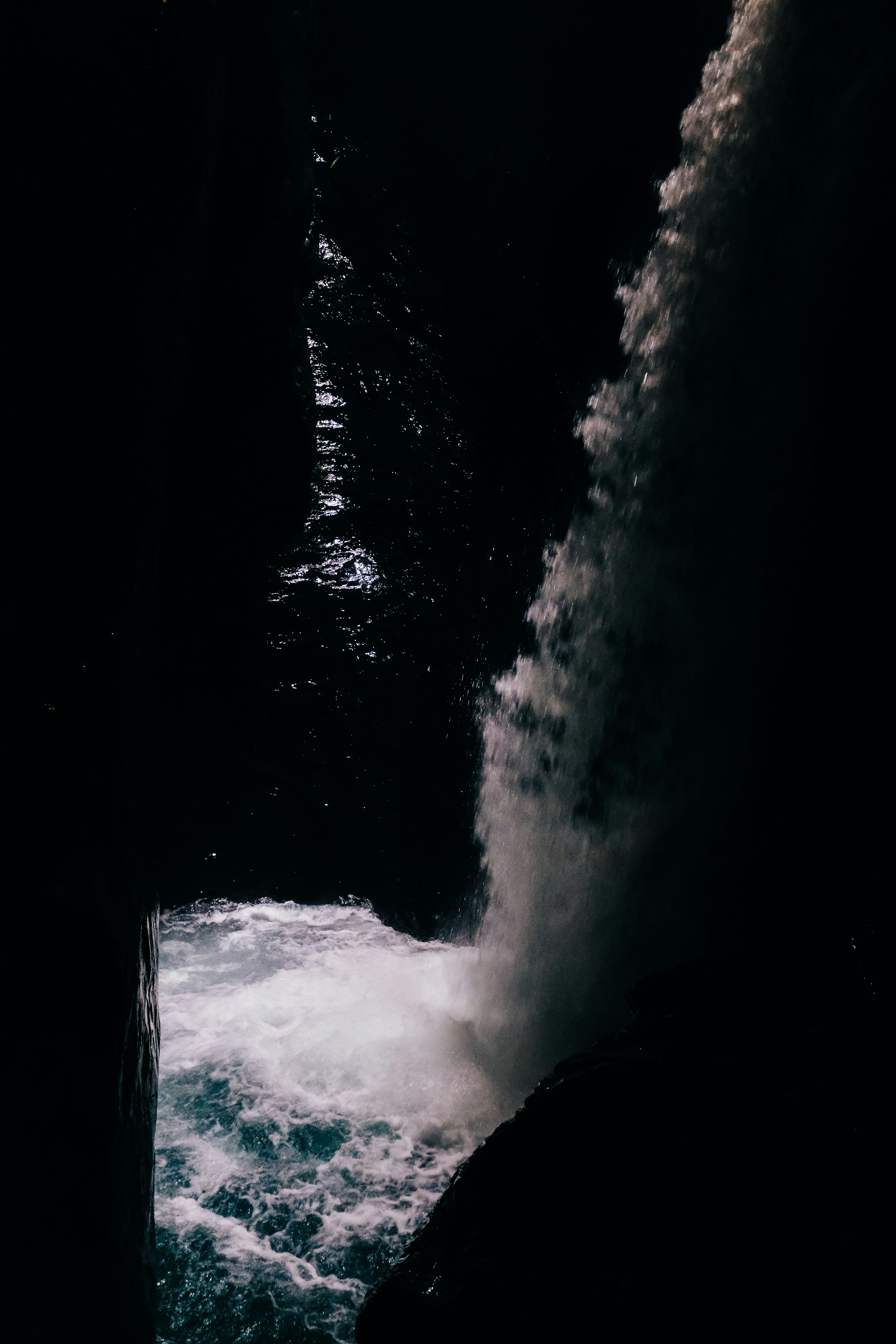 a person standing on a rock next to a body of water