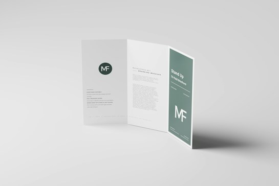 A clean and minimalist tri-fold brochure displayed on a light gray surface. The brochure is partially open, revealing sections with text and graphical elements. A prominent &lsquo;MF&rsquo; logo appears, and there are styled text blocks.