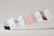 A series of connected rectangular paper flaps arranged in a zigzag pattern, featuring text and imagery. The paper design includes various sections with different colors such as white, navy, pink, and a section with a mountain landscape image. The layout appears professional and modern, with clean typography and minimalistic design elements.