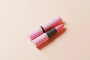 Close-up of a vintage peach-colored lipstick tube with soft natural light highlighting its creamy texture
