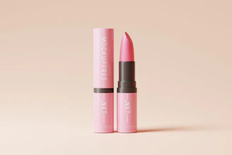 Close-up of a vibrant lipcream tube with smooth, creamy texture against a soft pink background.