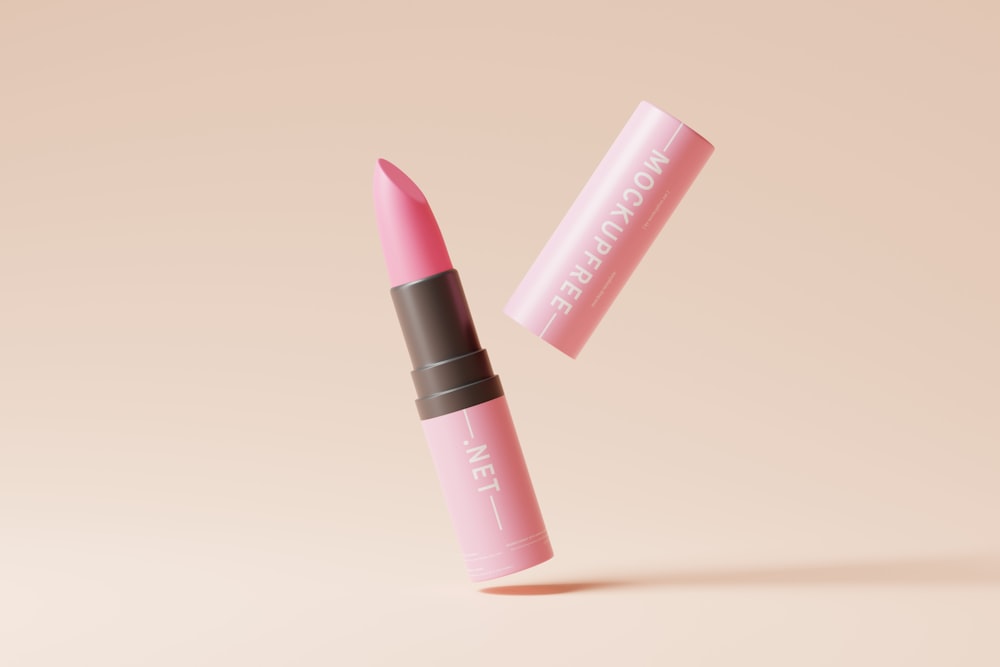 a pink lipstick with a brown cap on a pink background