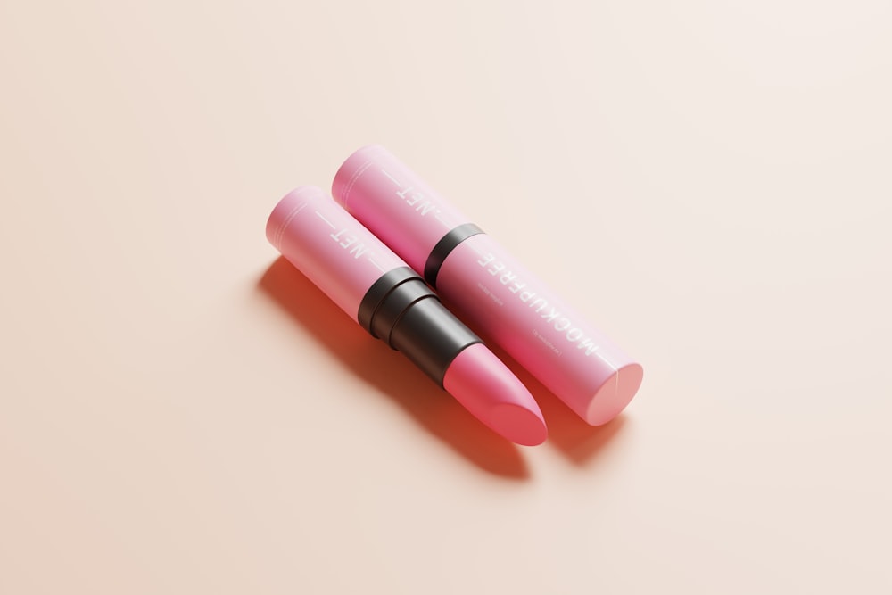 two pink lipsticks sitting on top of each other