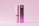 A lipstick tube and its box are displayed against a pink background. The tube is cylindrical with a light pink color and white text reading 'mockupfree.net'. The box is rectangular with a gradient from black to purple, featuring the text 'Lipstick and Box Mockups'.