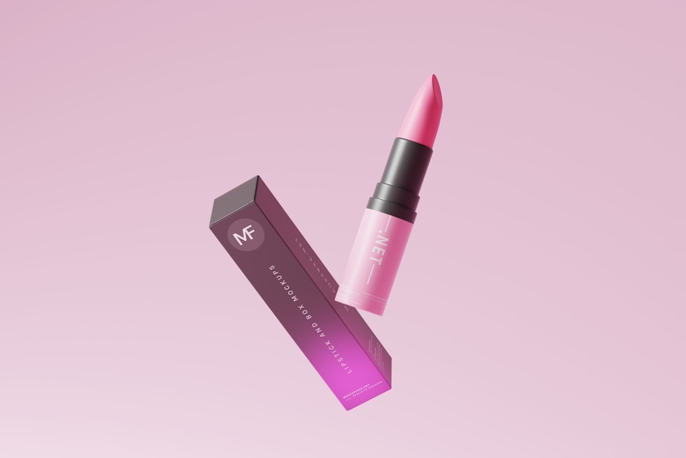 a pink lipstick with a black lid on a pink background