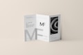 A tri-fold DL brochure mockup on a beige background. The brochure features modern typography and geometric design elements, with one panel displaying a black-and-white image of a spiral pattern. The brochure text includes a prominent 'MF' logo.