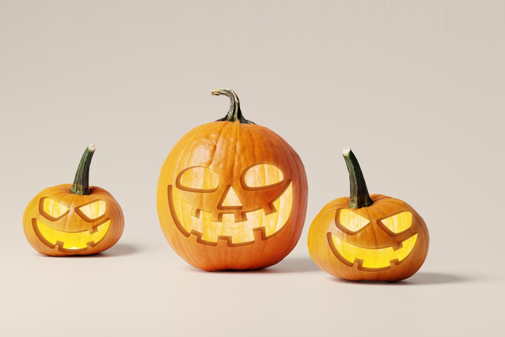 three carved pumpkins with faces carved into them