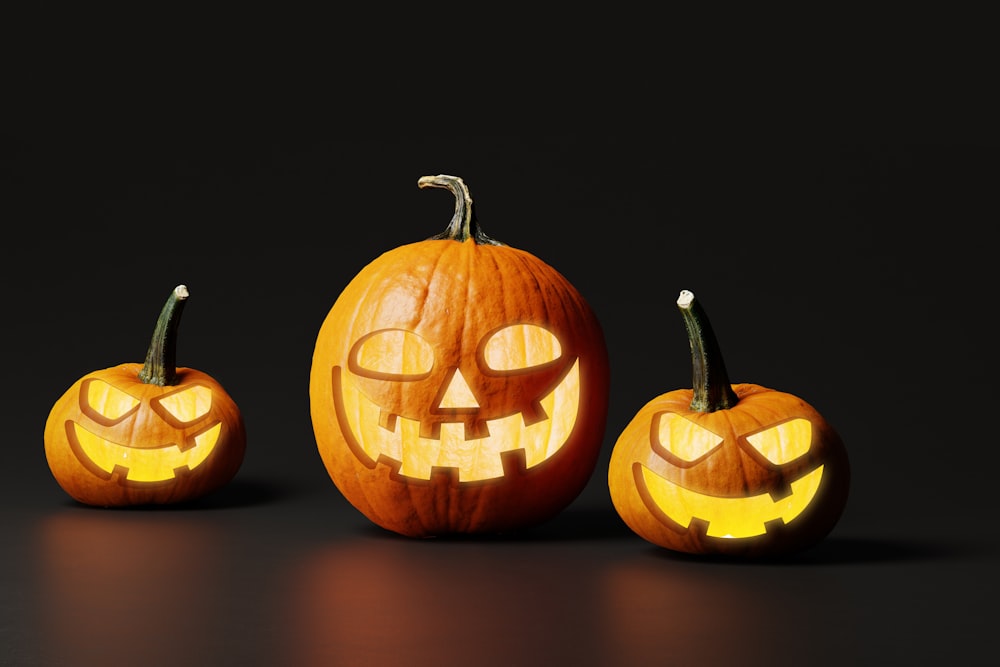 three carved pumpkins with faces carved into them