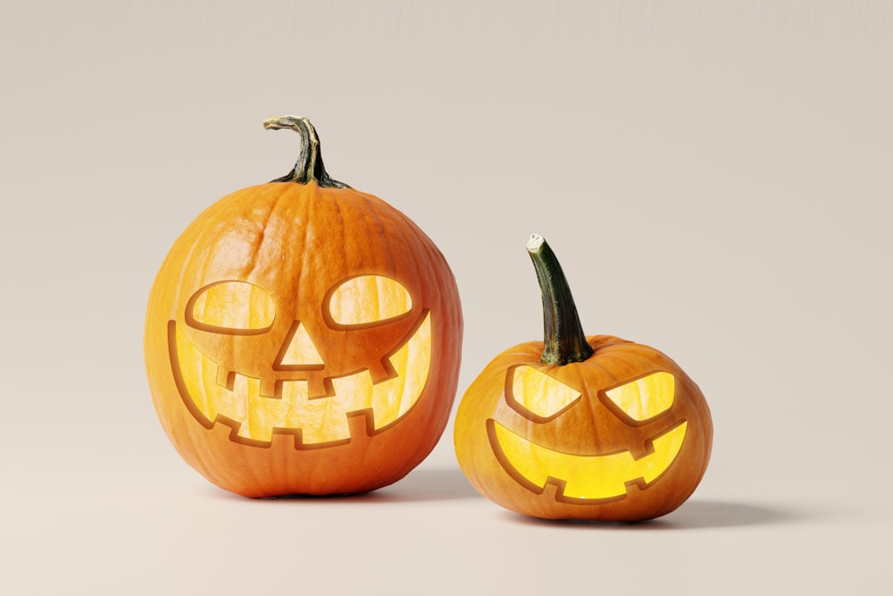 two carved pumpkins with faces carved into them