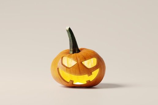 A spooky pumpkin with a mischievous grin surrounded by colorful autumn leaves.